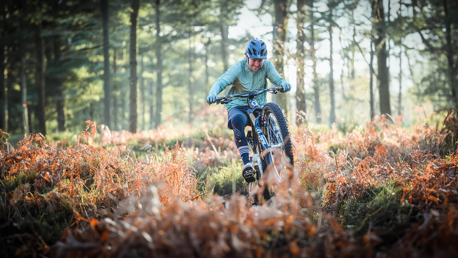 Mountain bike rider in a field. wearing the Drift collection